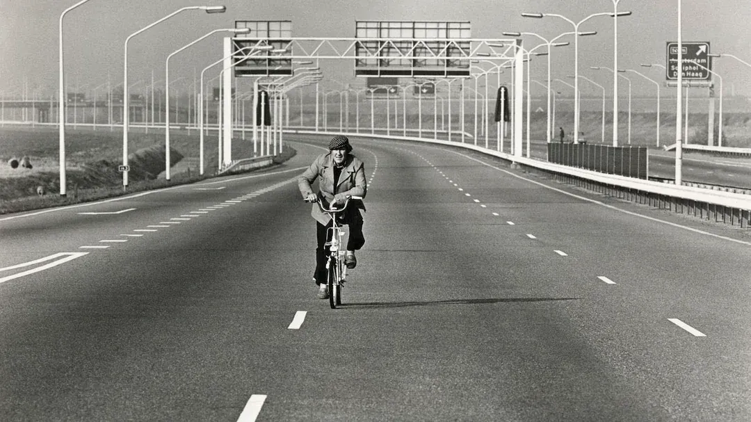 Mężczyzna jedzie rowerem pustą autostradą w Holandii podczas niedzielnego zakazu jazdy samochodem w czasie kryzysu naftowego 1973 roku
